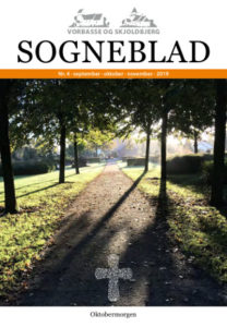 Et kig ind under lindetræer på plænekirkegården i Vorbasse. Forside på sogneblad nr. 4 2019